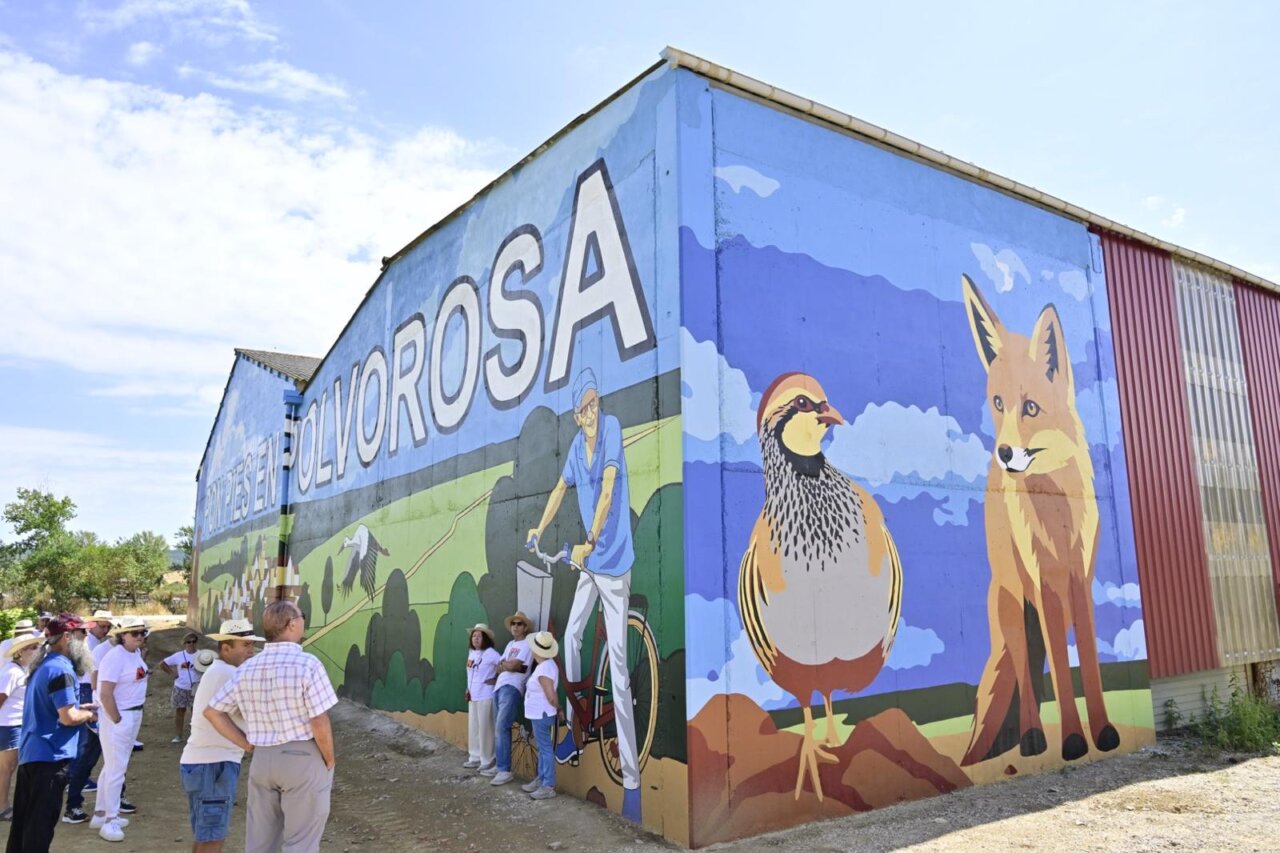 Mural colorido en Polvorosa de Valdavia con personas observando