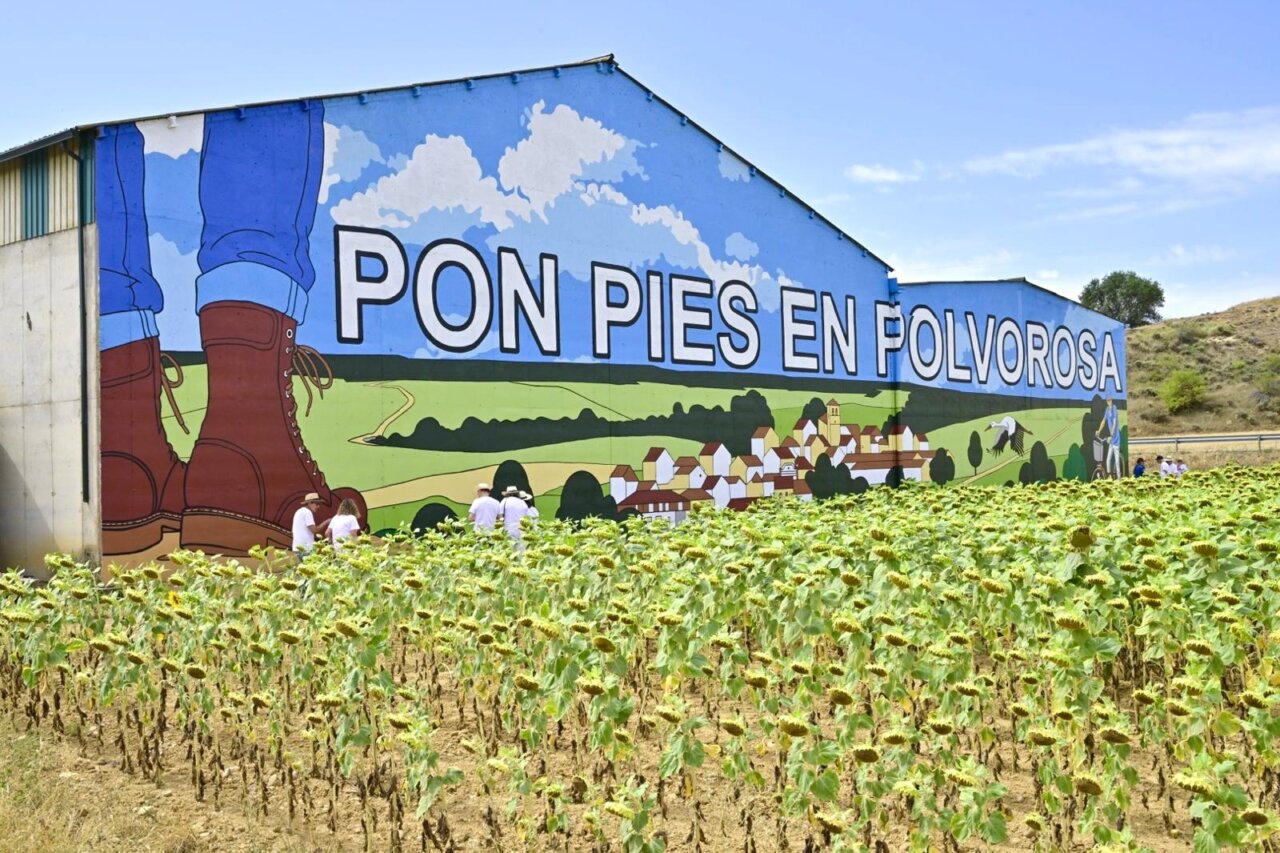 Mural colorido en Polvorosa de Valdavia con texto y paisaje