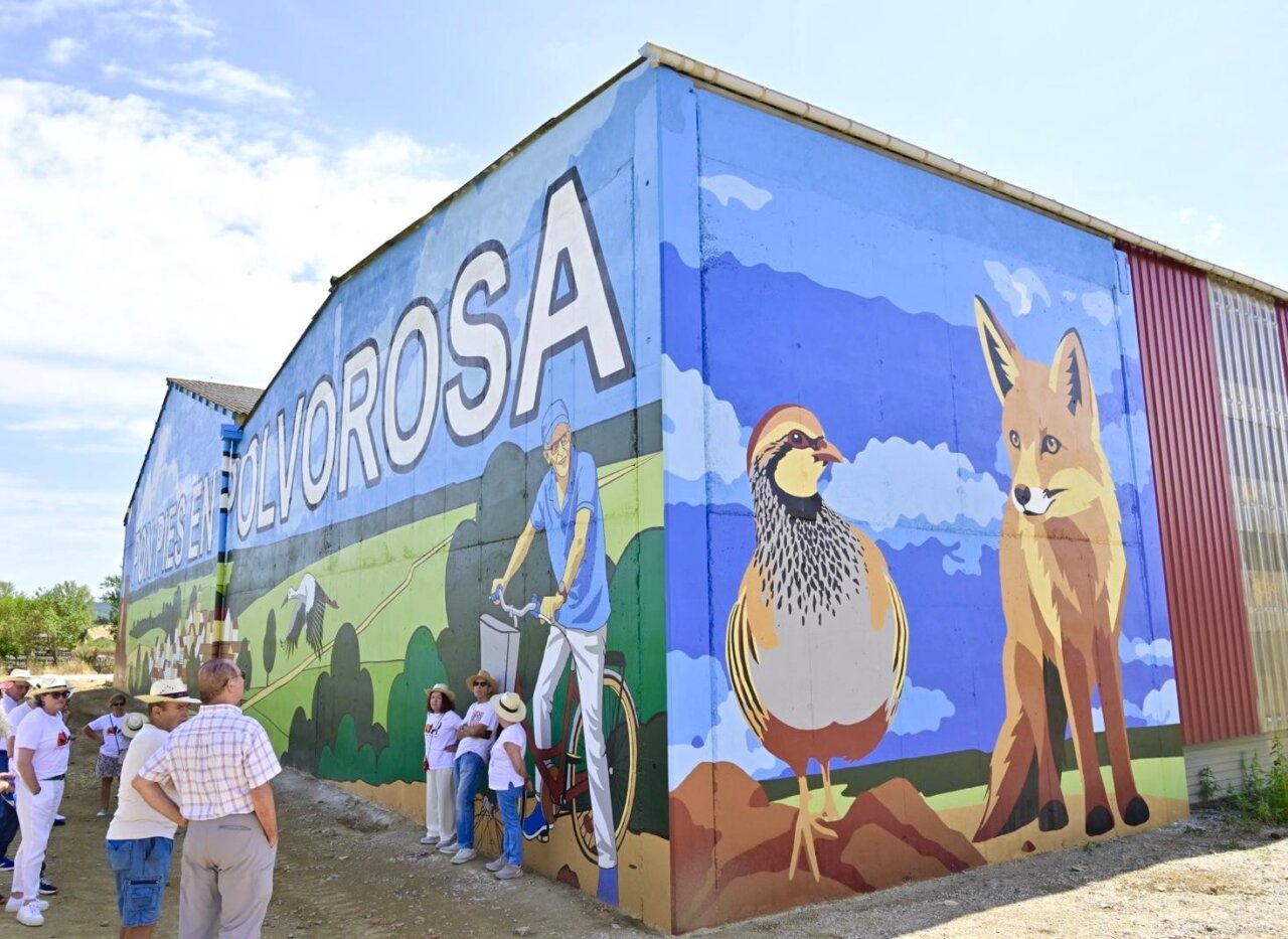 Mural colorido en Polvorosa de Valdavia con personas observando