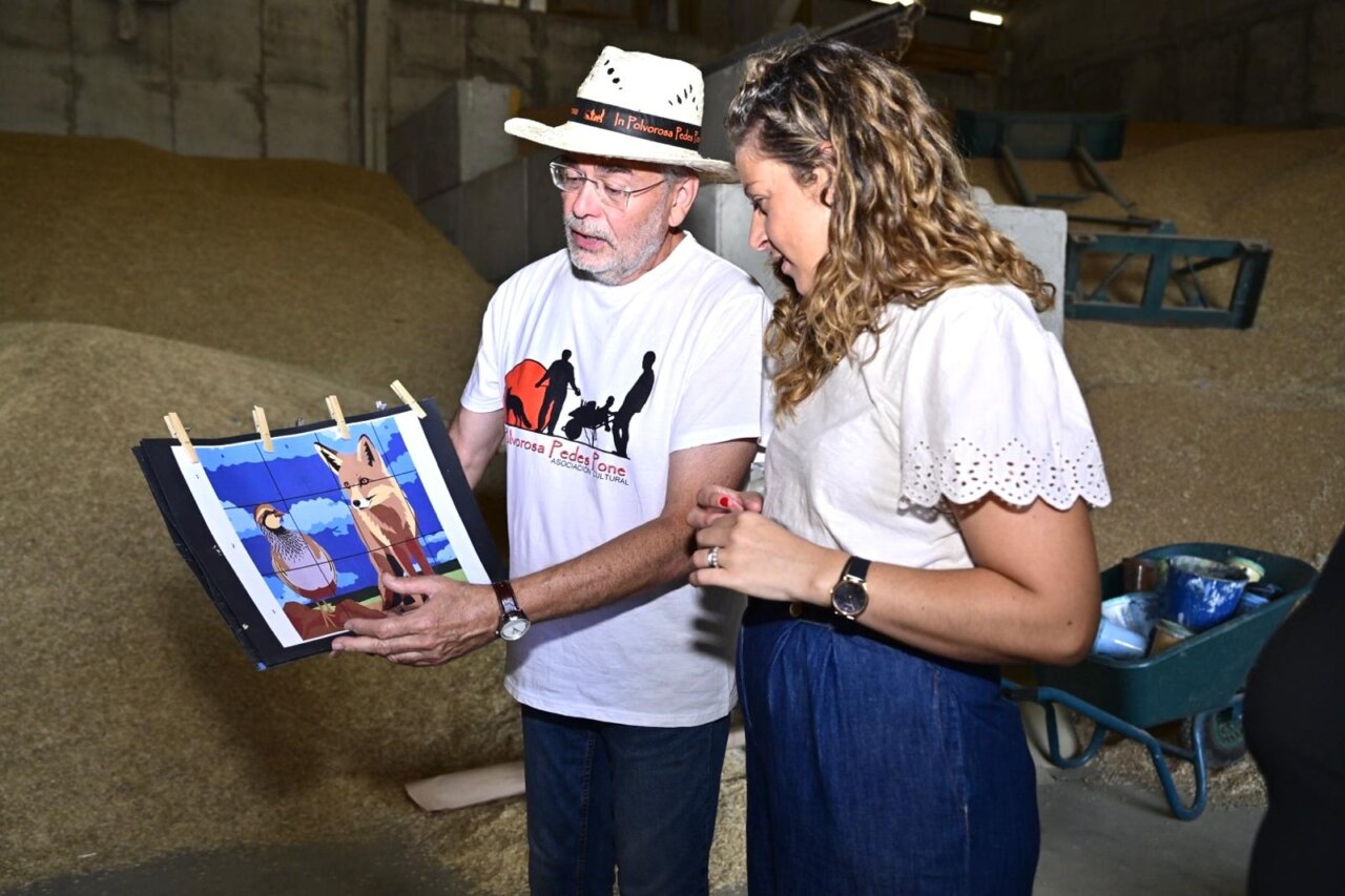 Dos personas observando un diseño de mural en Polvorosa de Valdavia