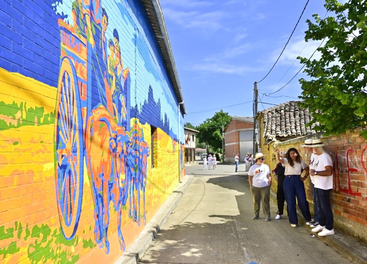 Mural colorido en Polvorosa de Valdavia con vecinos admirando la obra