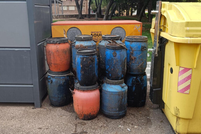 Bidones de aceite usados abandonados junto a un contenedor en Pan y Guindas