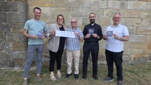 Grupo de personas mostrando acreditaciones de patrimonio religioso en Palencia