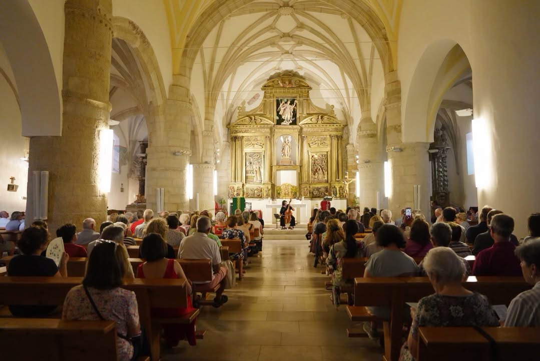 Concierto en una iglesia con numerosos asistentes disfrutando de la música