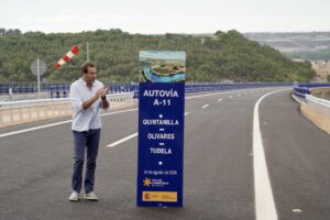 Inauguración de la A-11 con un hombre aplaudiendo junto a un cartel