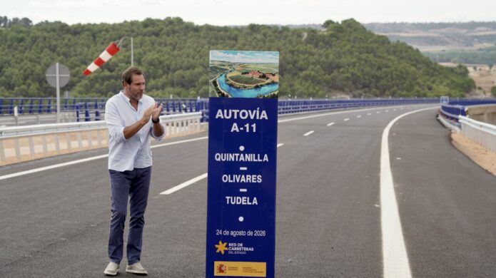 Inauguración de la A-11 con un hombre aplaudiendo junto a un cartel