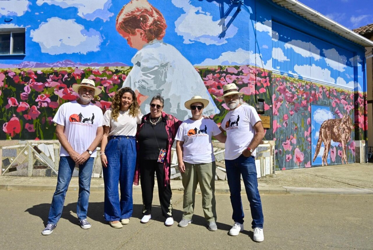 Grupo de personas frente a un mural colorido en Polvorosa de Valdavia