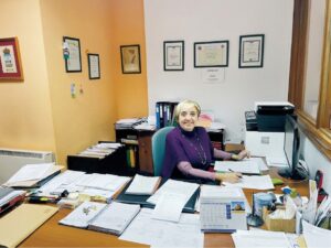Mujer en oficina de asesoría con documentos y computadora
