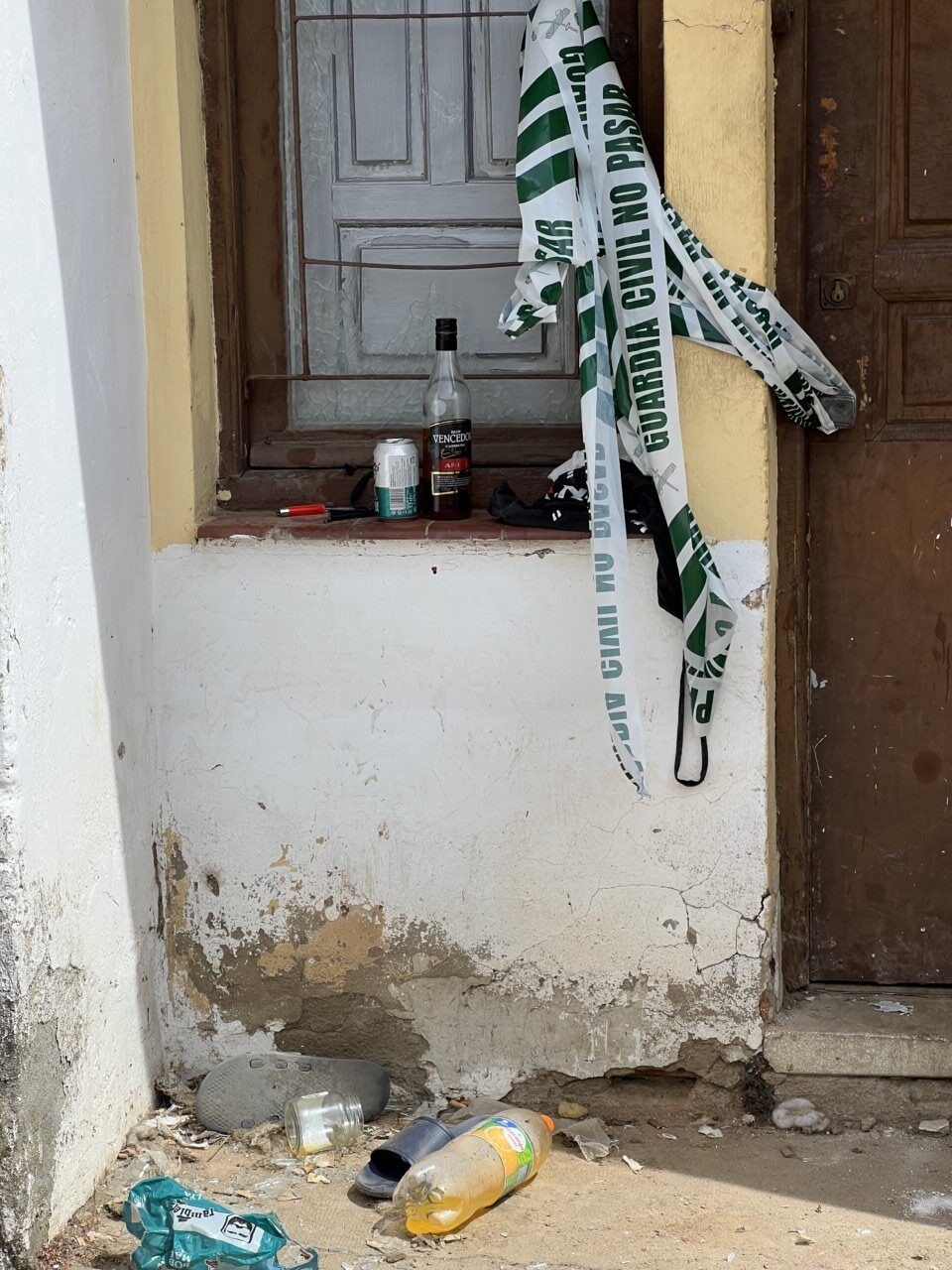 Escena de un lugar con cintas de la Guardia Civil y objetos en el suelo.