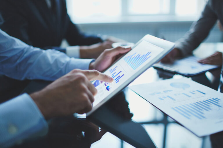 Primer plano de un empresario usando una tableta digital en una reunión
