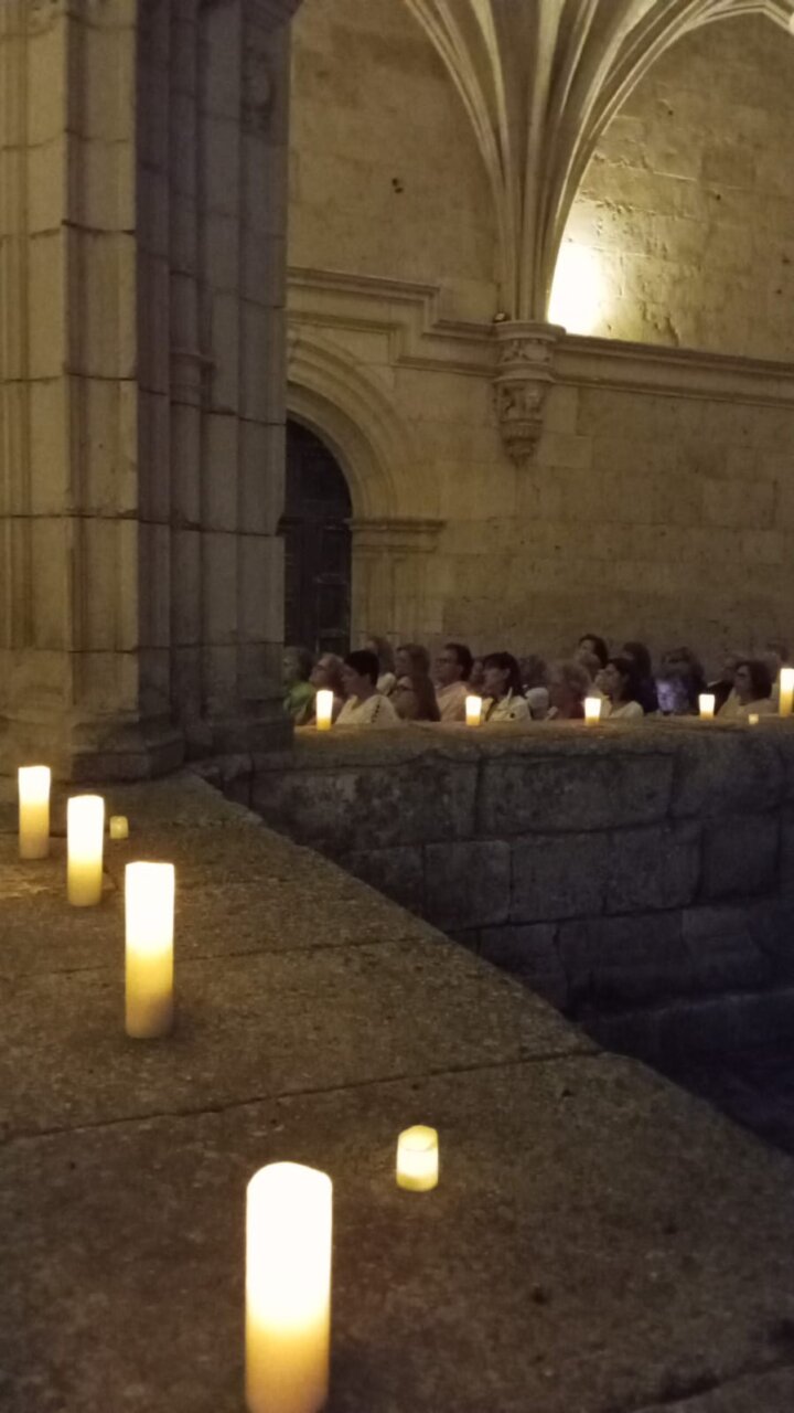 Asistentes al concierto en el Monasterio de San Zoilo con velas encendidas