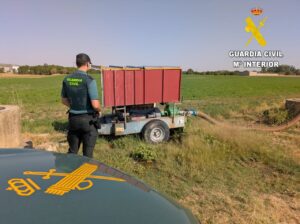Agente de la Guardia Civil inspeccionando un vehículo agrícola en un campo