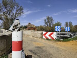 Muñecos de dinosaurio y conejo en un puente en Naveros de Pisuerga