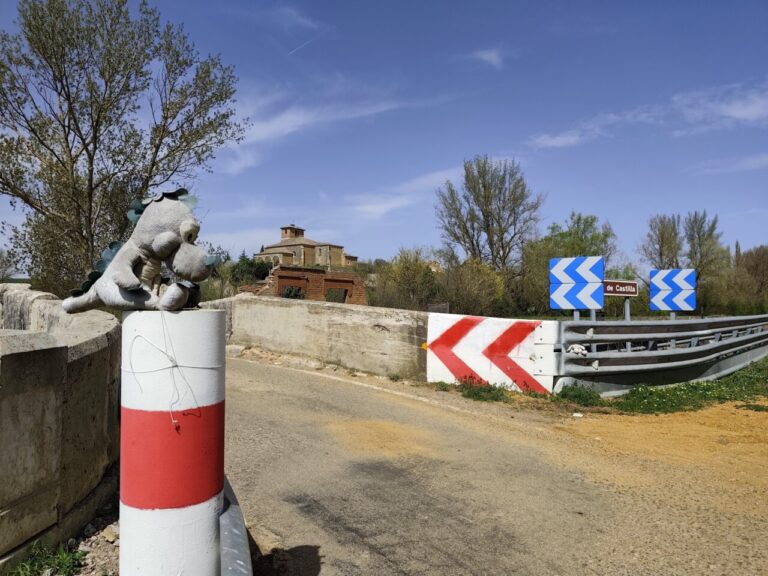 Muñecos de dinosaurio y conejo en un puente en Naveros de Pisuerga