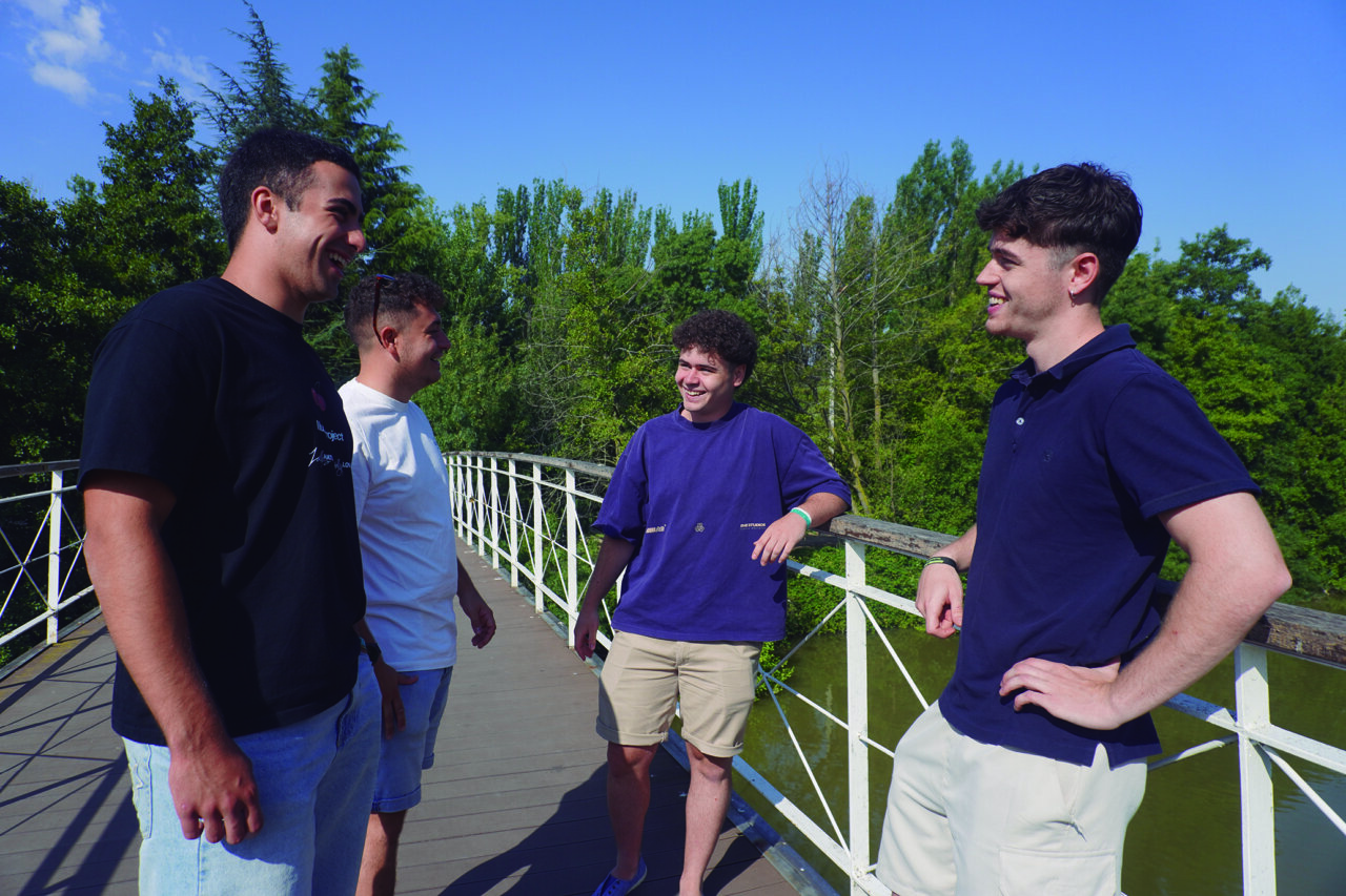 Cuatro jóvenes sonriendo en un puente en Cascón de la Nava