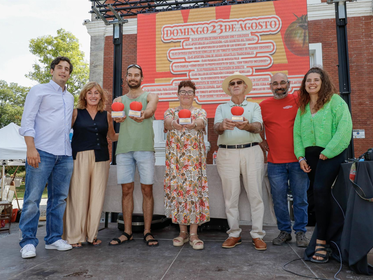 Emilio Medina y otros ganadores sosteniendo premios en feria del tomate