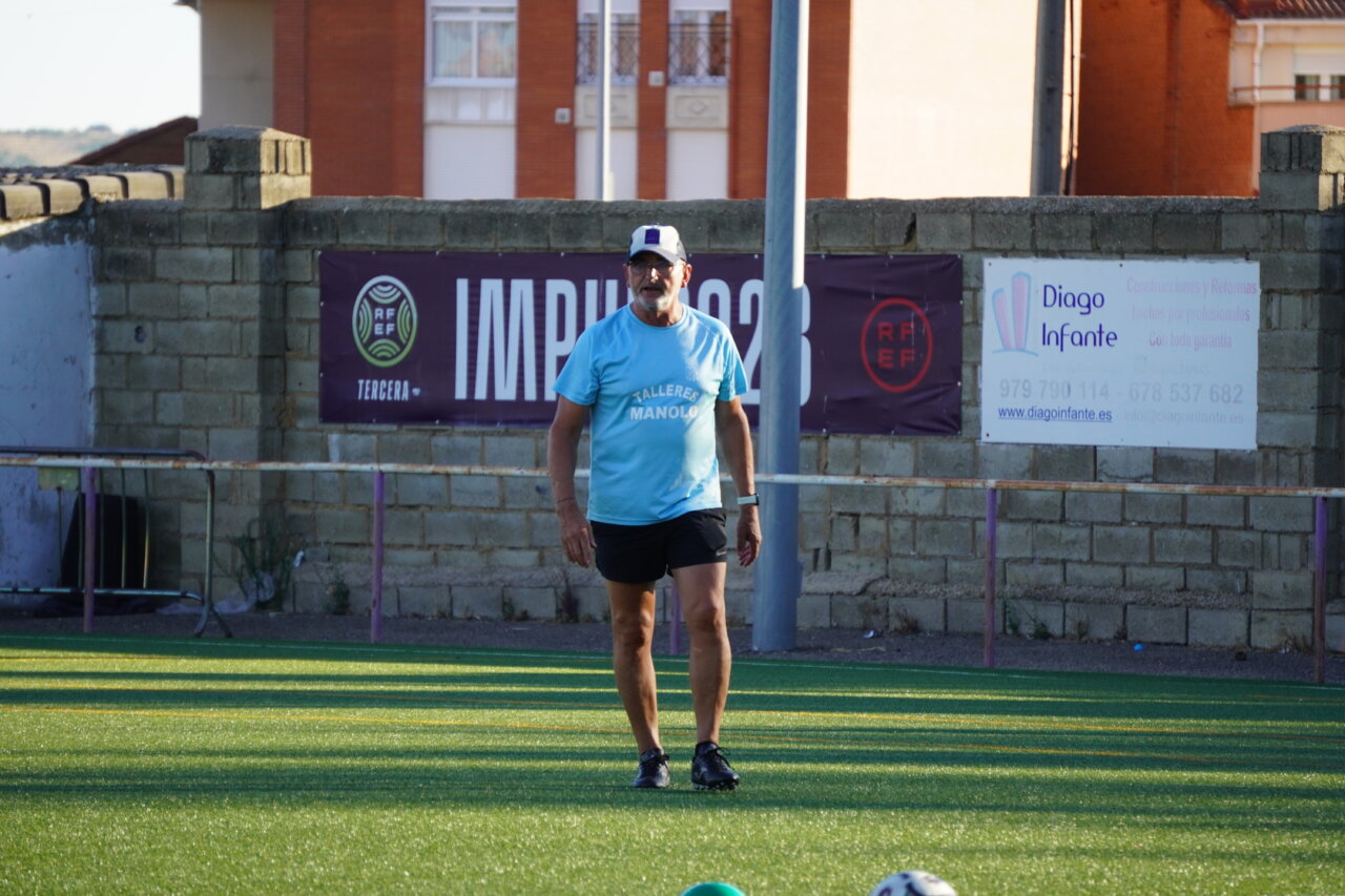 Entrenador del Palencia Fútbol Femenino dirigiendo un entrenamiento en el campo.