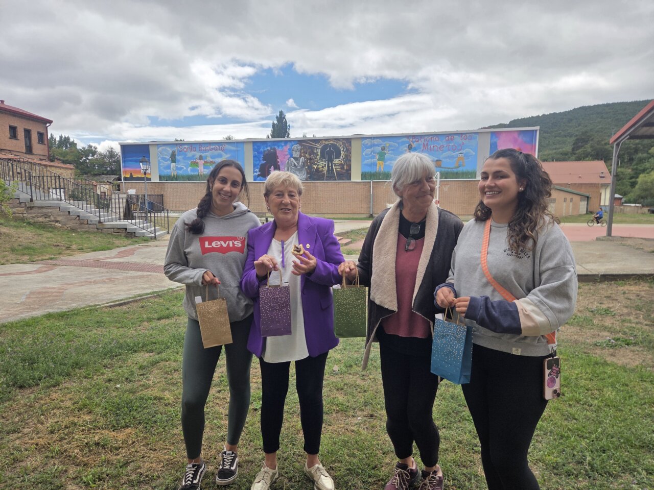 Cuatro mujeres sosteniendo obsequios en la clausura de la Escuela de Verano de Barruelo.