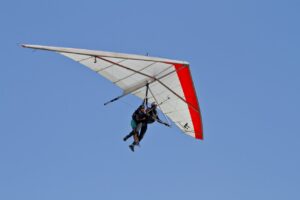 Persona volando en un ala delta sobre un cielo azul claro