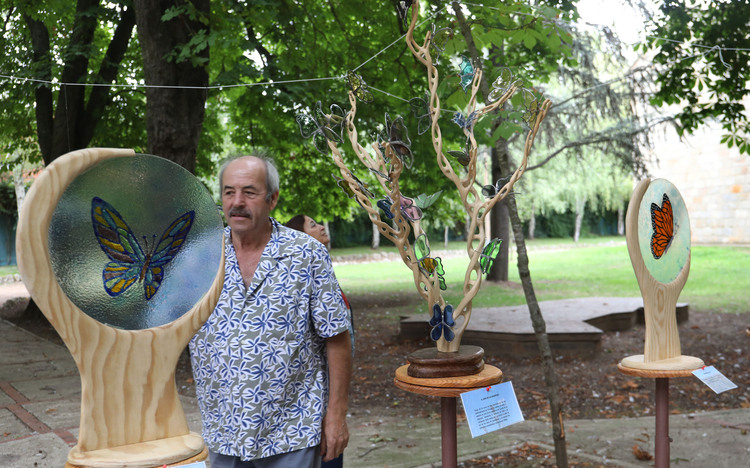 Artista junto a esculturas de mariposas en Expo Aire Palencia