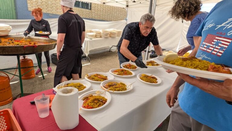 Personas sirviendo paella en las fiestas de Husillos junto al río Carrión.
