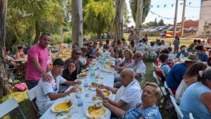 Grupo de personas disfrutando de una paellada en las fiestas de Husillos