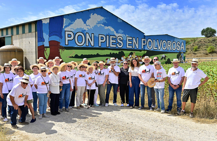 Grupo de personas posando frente a un mural en Polvorosa de la Valdavia