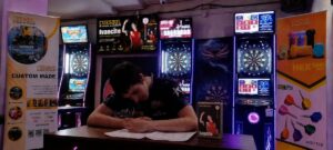 Ivancito firmando contrato con CUESOUL en un evento de dardos