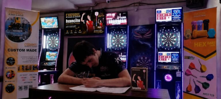 Ivancito firmando contrato con CUESOUL en un evento de dardos