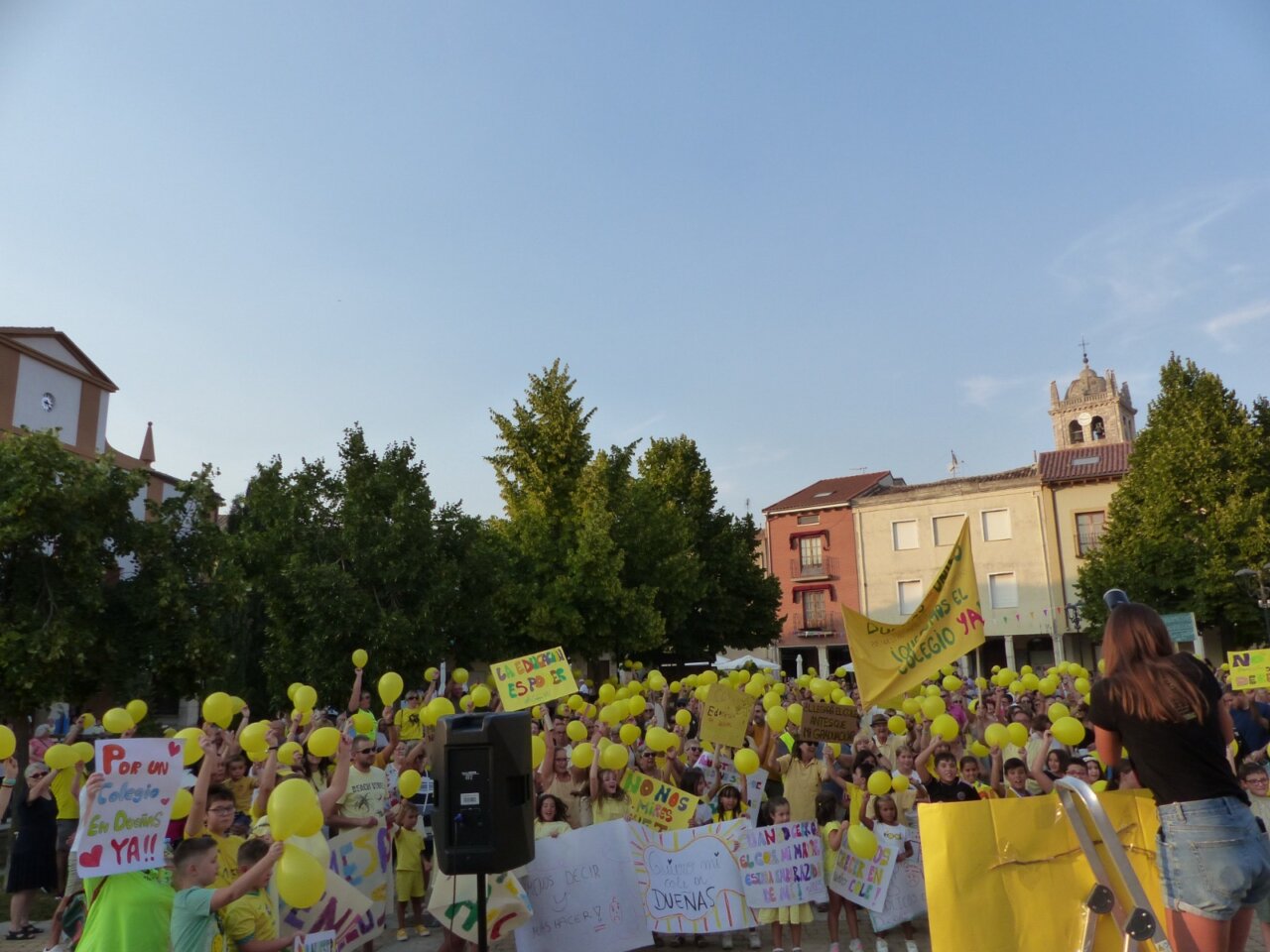 Concentración en Dueñas con globos amarillos y pancartas por un nuevo colegio