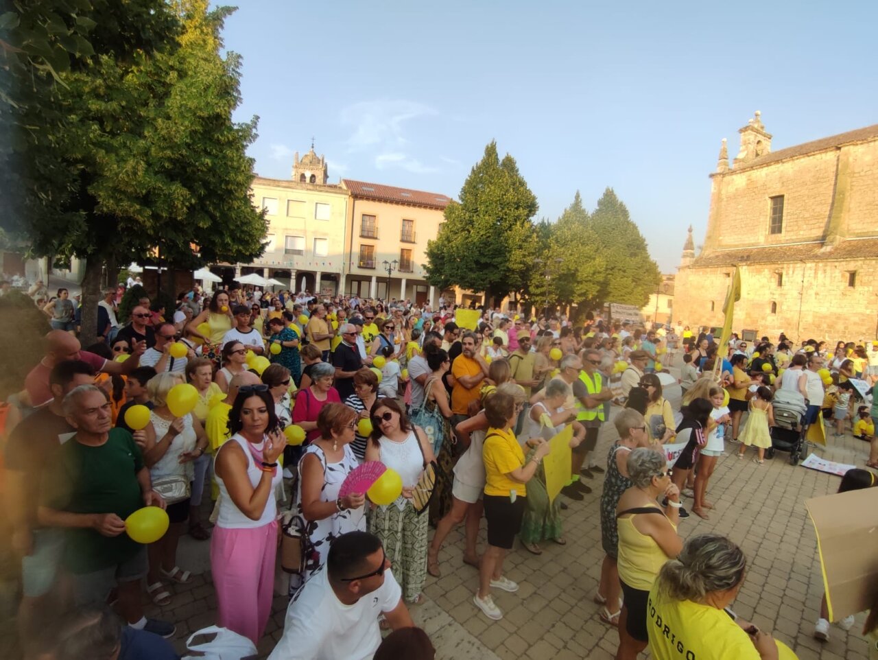 Concentración en Dueñas con globos amarillos para exigir un nuevo colegio