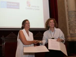 María Pardo y otra mujer firmando documentos en un evento oficial