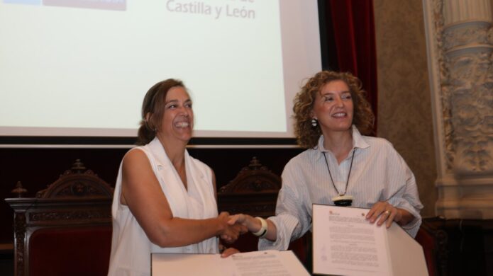 María Pardo y otra mujer firmando documentos en un evento oficial