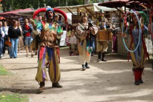Actores disfrazados en el Mercado Medieval de Palencia con música y coloridos trajes