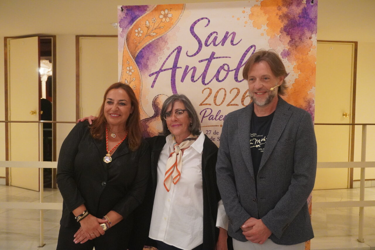 Tres personas posan frente a un cartel del pregón literario de San Antolín 2026.
