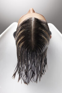 Vista superior de una cabeza con cabello mojado en un salón de peluquería