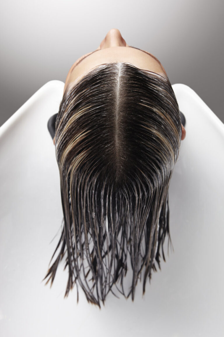 Vista superior de una cabeza con cabello mojado en un salón de peluquería