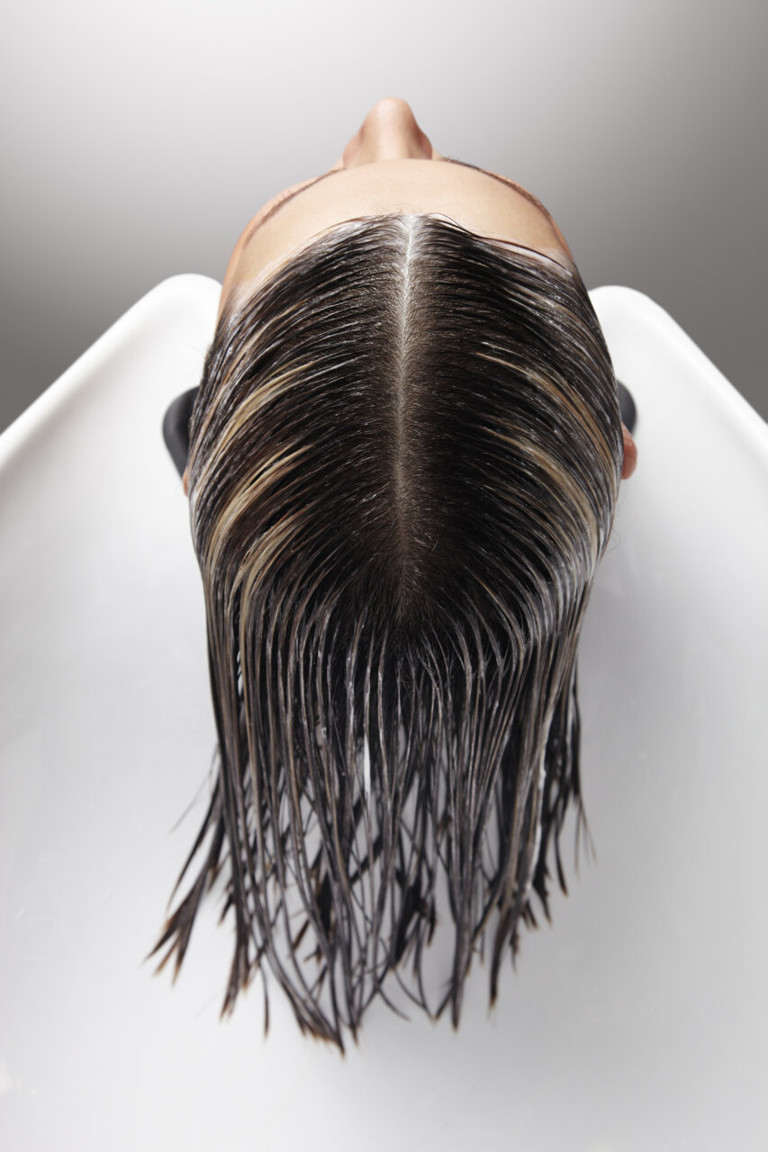 Vista superior de una cabeza con cabello mojado en un salón de peluquería