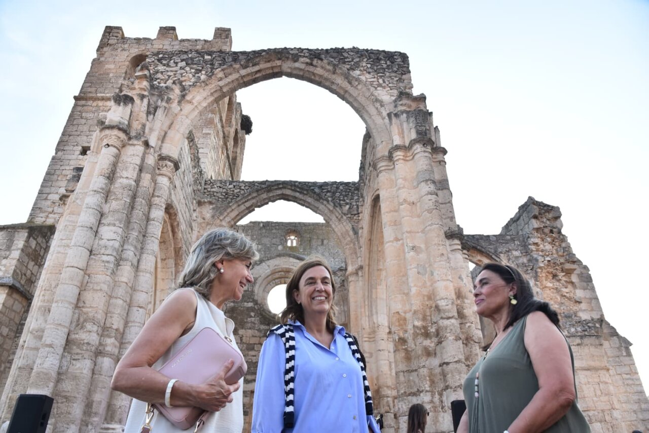 Tres mujeres conversando frente a las ruinas de la iglesia de Santa Eulalia en Palenzuela