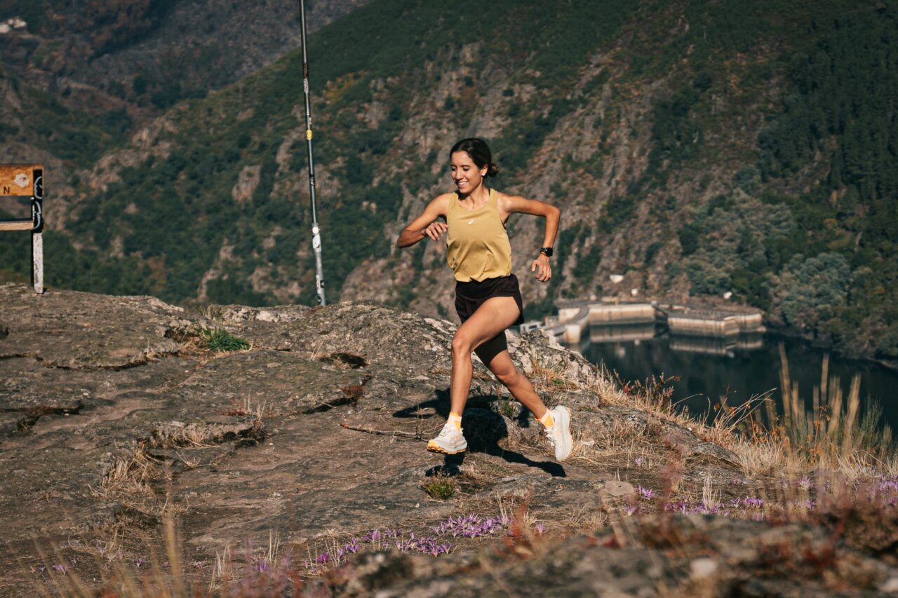 Sara García corriendo en un paisaje montañoso con energía y determinación