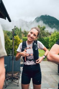 Sara García sonriendo con un chaleco de hidratación en un entorno natural
