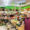 Interior del supermercado Axel y Luna con productos frescos y una empleada sonriendo.