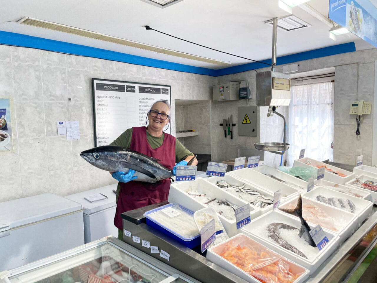 Mujer sosteniendo un pez en la pescadería del supermercado Axel y Luna
