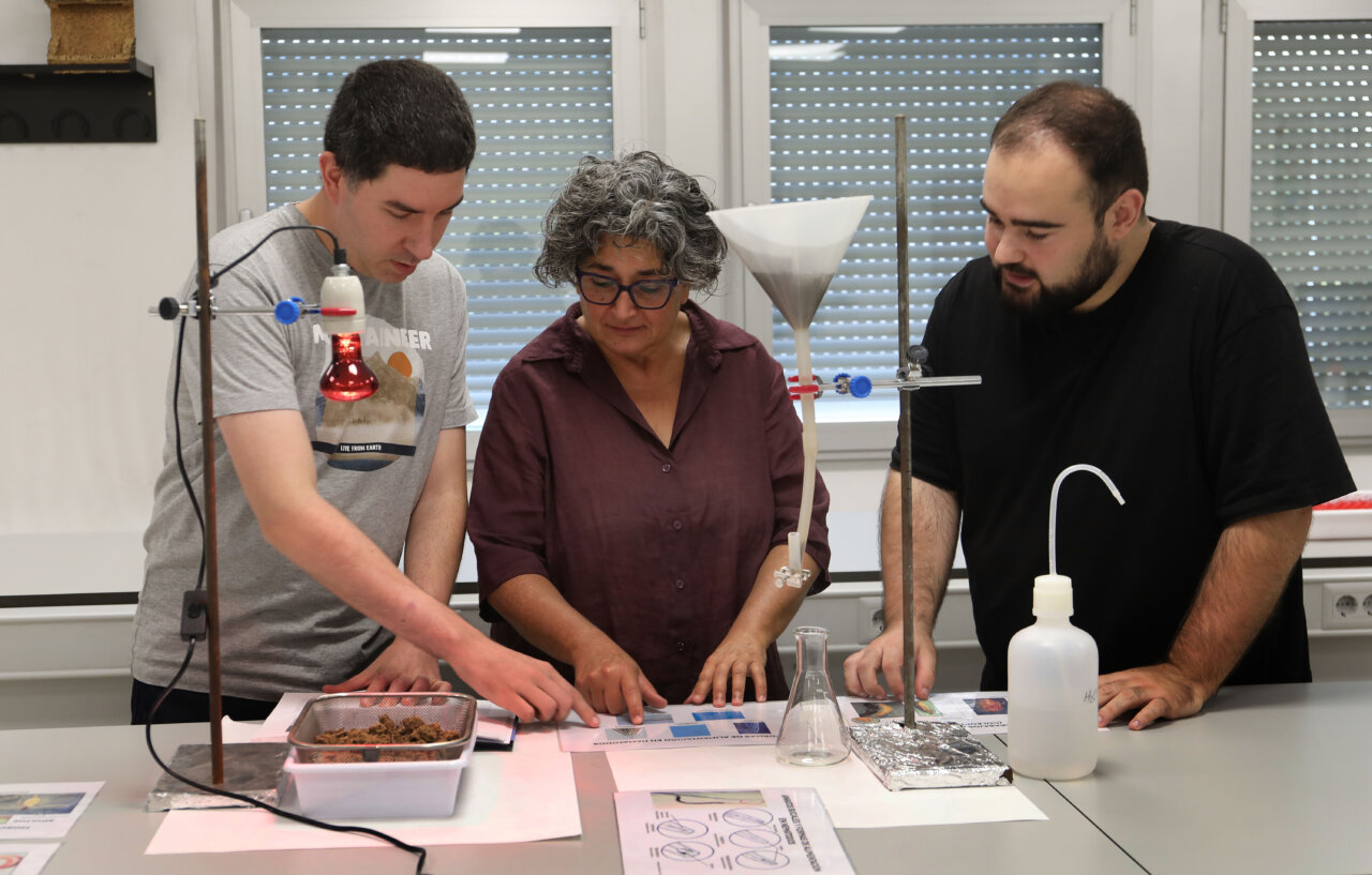 Tres personas trabajando en un laboratorio sobre la recuperación de una mina de carbón.