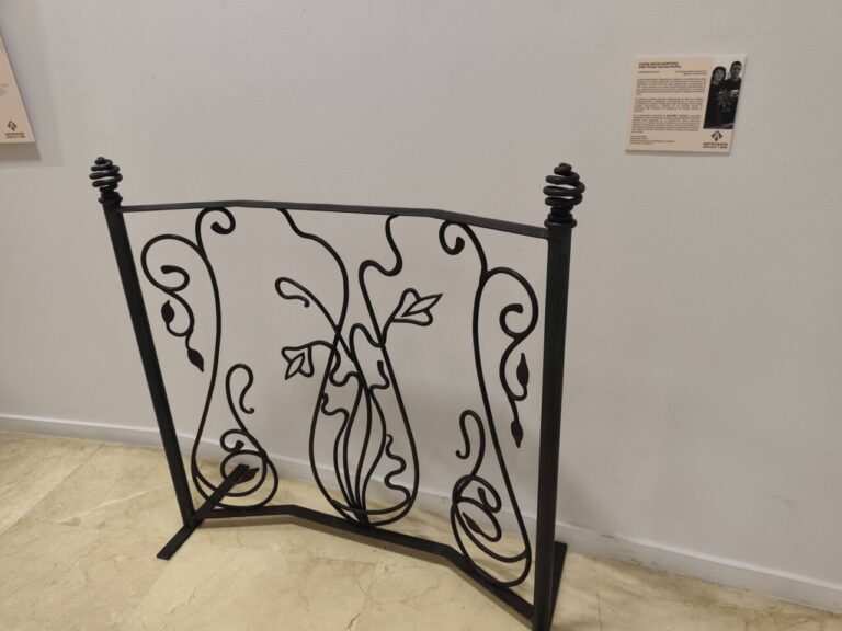 Reja de hierro forjado con diseño floral en exposición de artesanía