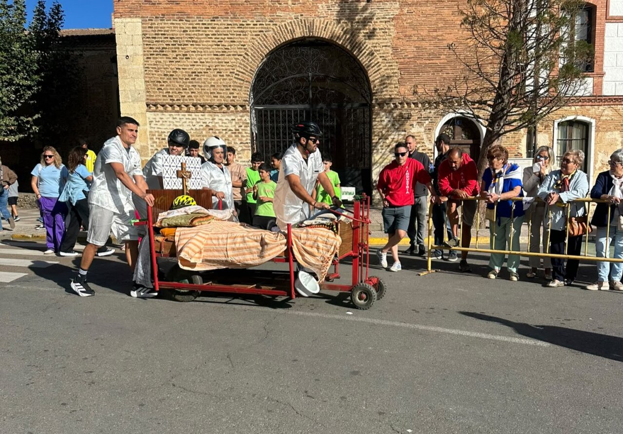 Participantes empujando una cama decorada en la carrera de camas en Saldaña