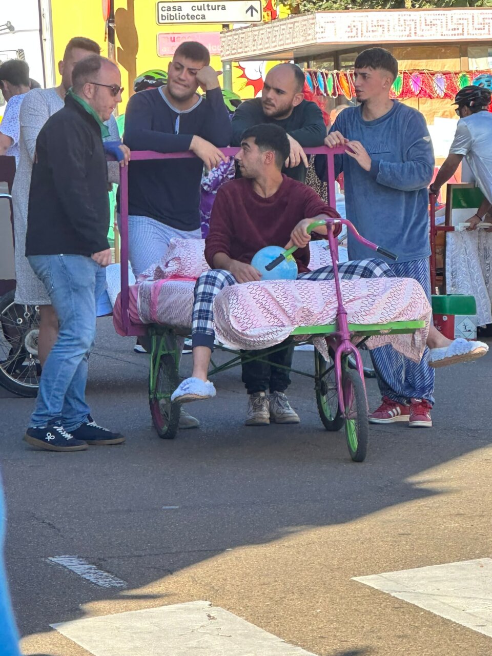 Participantes en la Carrera de Camas en Saldaña, con disfraces y una cama decorada.