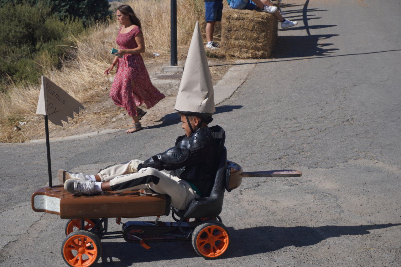Niño participando en la carrera de autos locos con un disfraz divertido