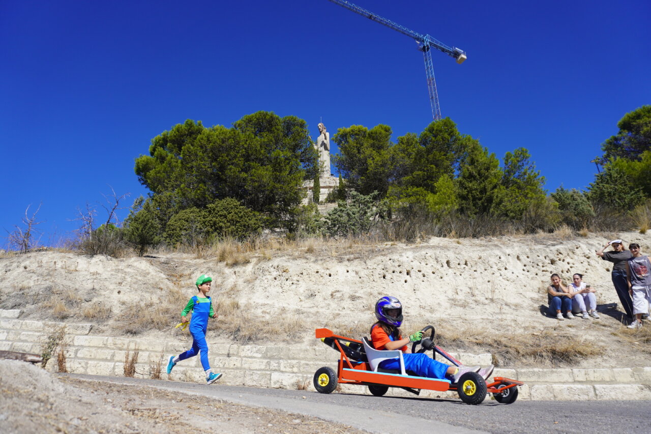 Niño corriendo junto a un kart en la carrera de autos locos