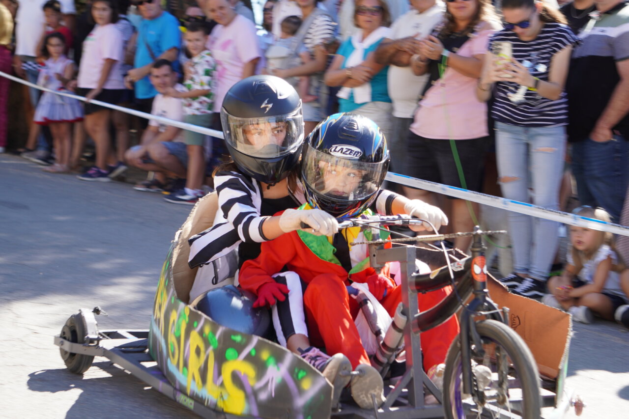 Participantes en la carrera de autos locos en Palencia con disfraces coloridos